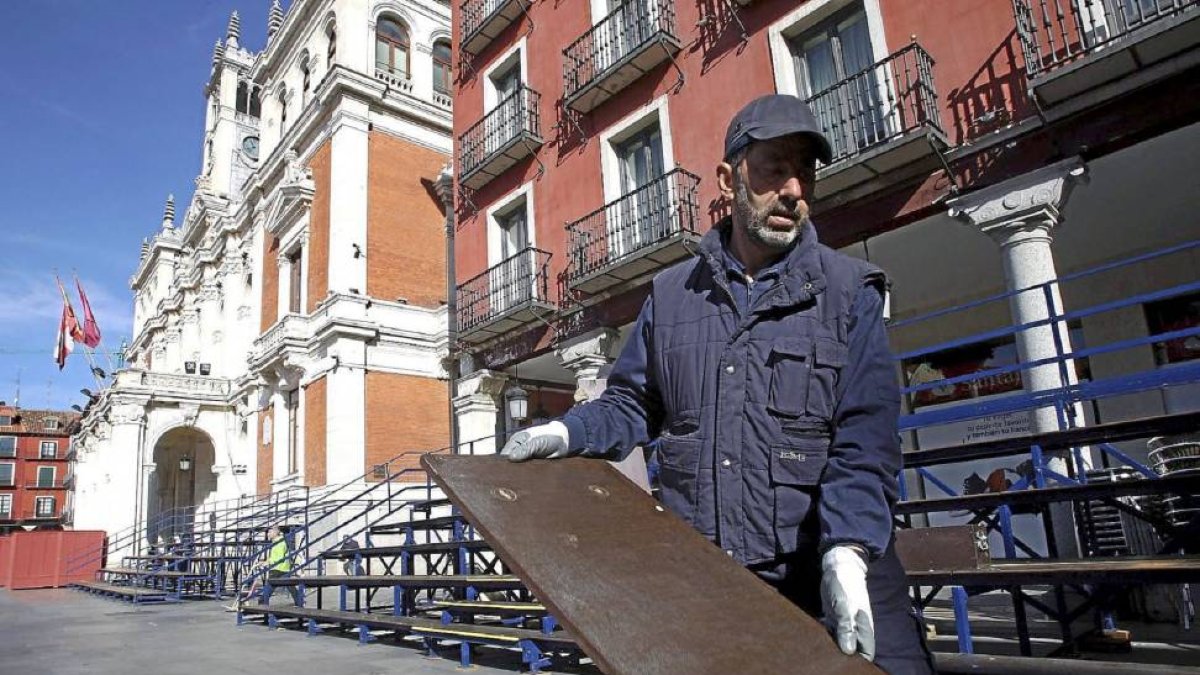 Un operario retira las gradas de Semana Santa en la Plaza Mayor-Ical
