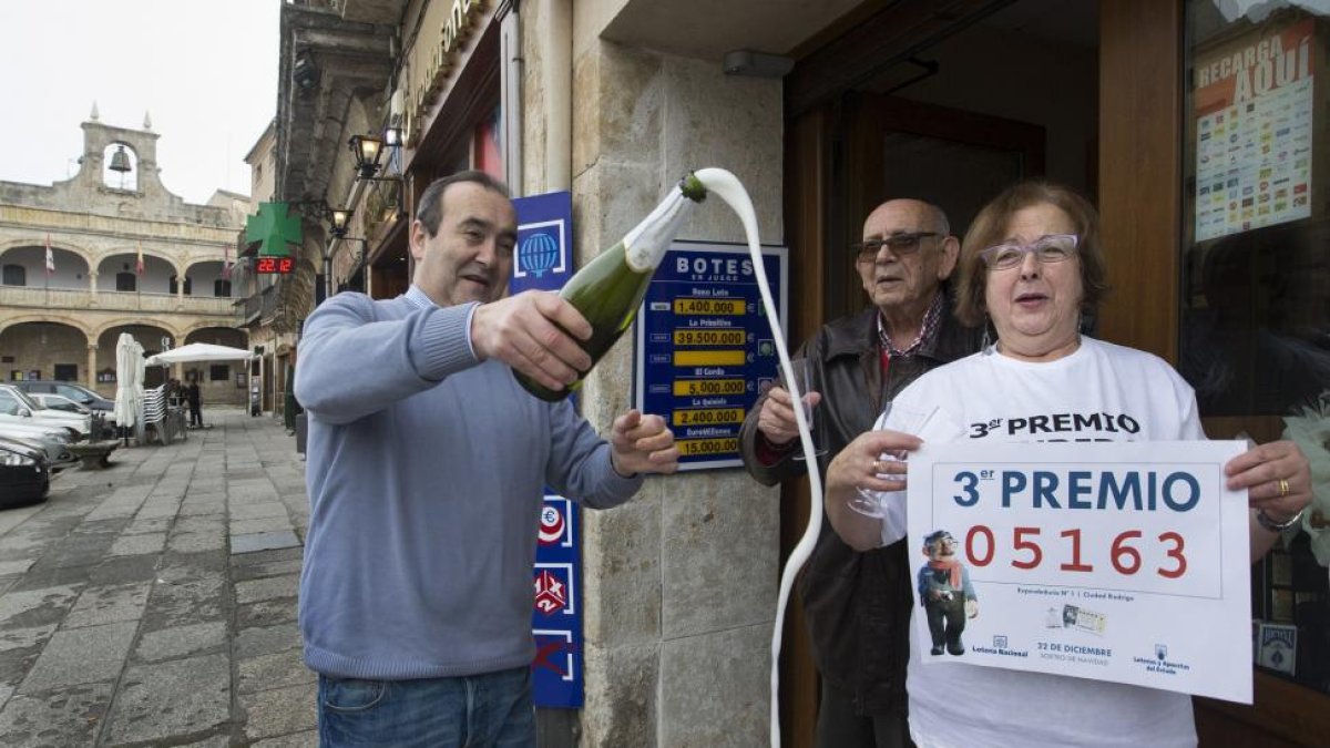 Los propietarios del estanco de la Plaza Mayor de Ciudad Rodrigo, que cuenta con terminal de venta de Lotería, brindan con champán al vender parte del tercer premio de la lotería..-ICAL