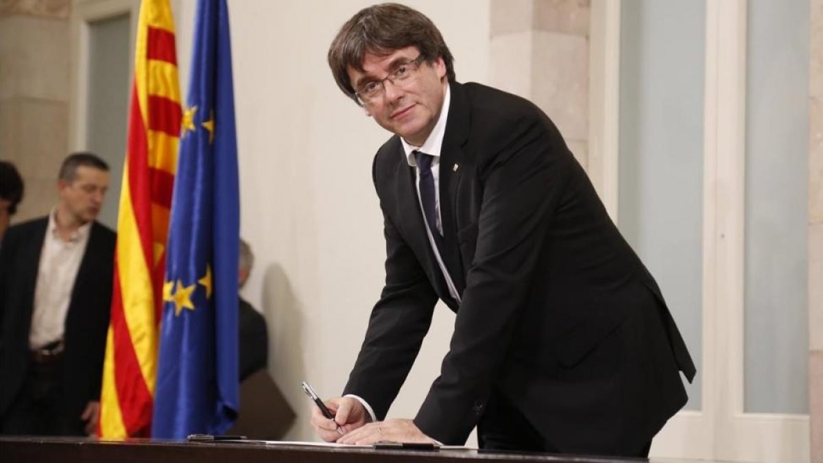 El president Carles Puigdemont en el momento de firmar la declaración, tras el pleno-JULIO CARBÓ