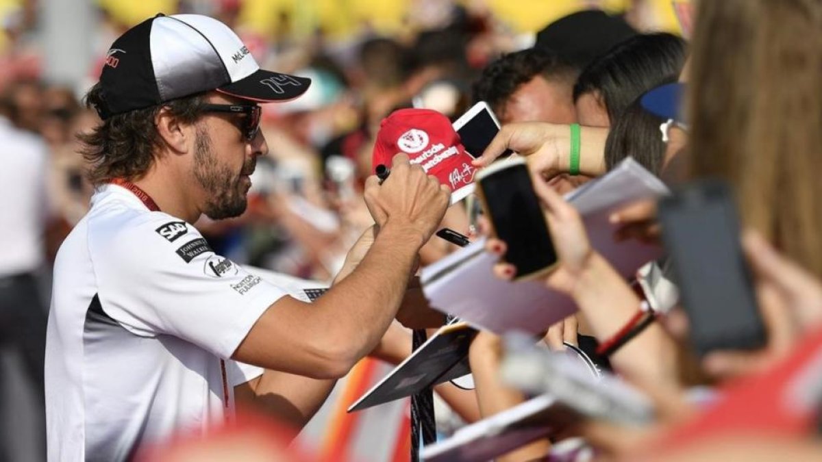 Fernando Alonso firma autógrafos en Hungaroring.-EFE / ZSOLT CZEGLEDI