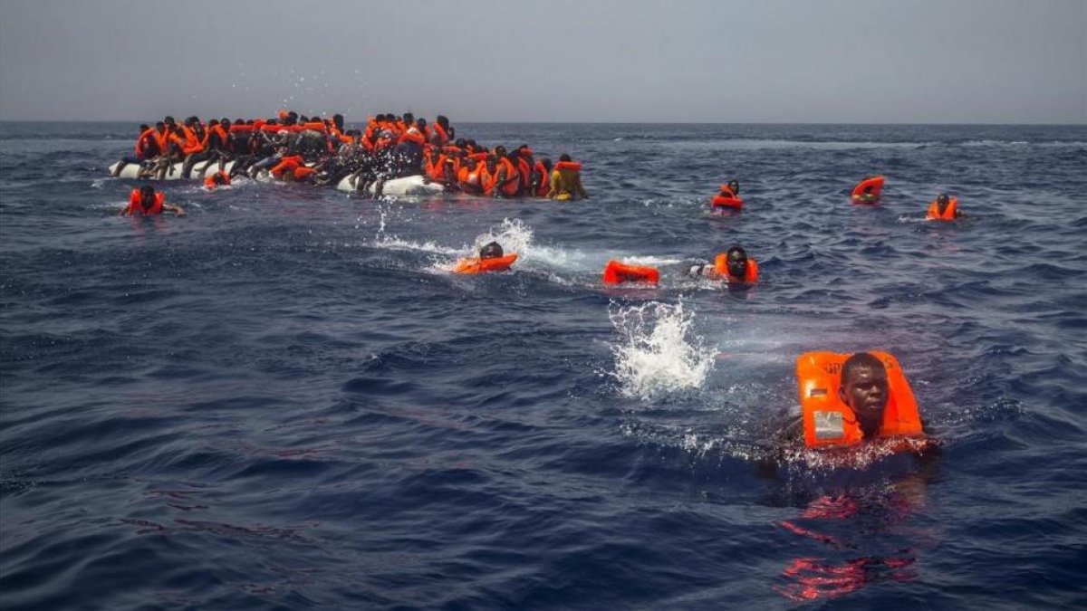 Un grupo de emigrantes y refugiados africanos intentan alcanzar a nado el barco de la oenegé Proactiva Open Arms el pasado 23 de julio.-AP / SANTI PALACIOS
