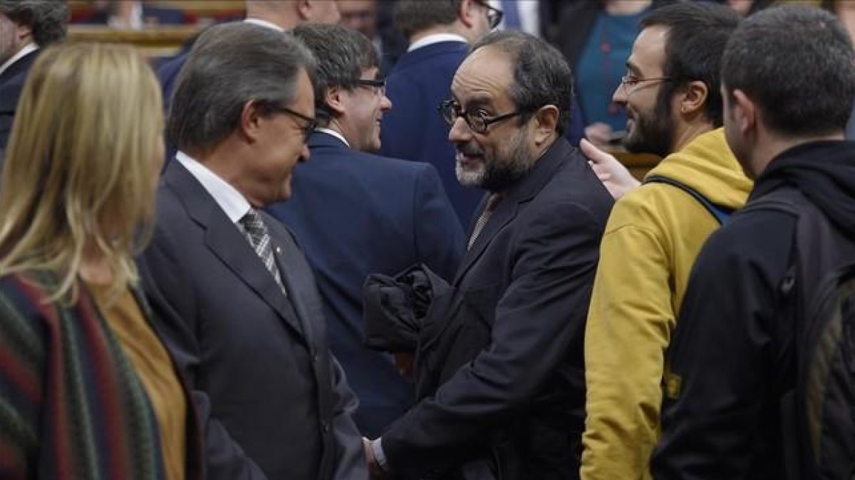 Artur Mas y Antonio Baños se saludan el pasado lunes antes del pleno de constitución del Parlament.-AFP / LLUÍS GENÉ