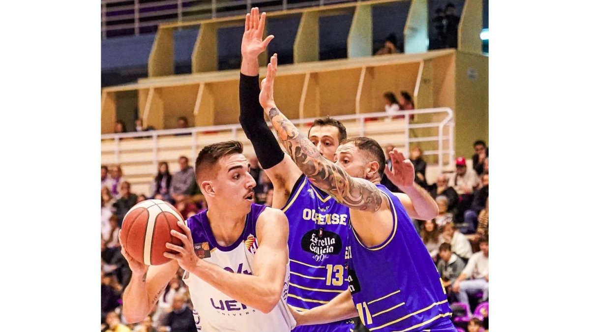 Alex Mazaira, en el poste bajo ante la defensa de dos jugadores de Ourense. RVB / ANA PUENTE