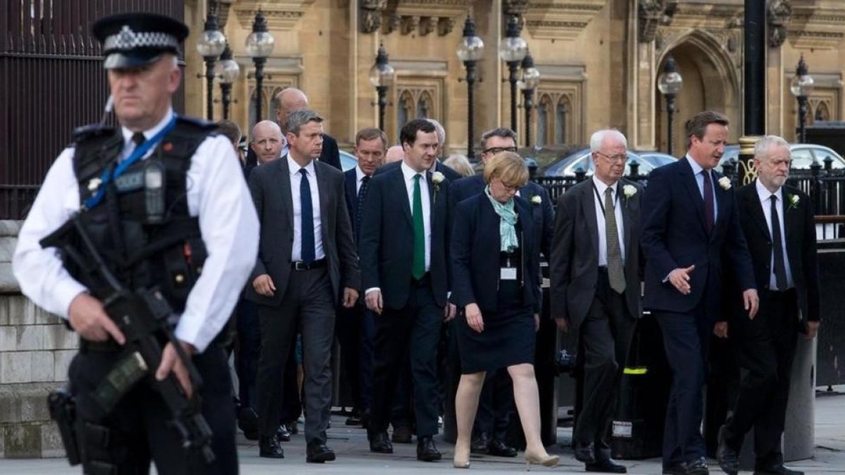 El primer ministro británico David Cameron (segundo por la derecha) camina junto al líder del partido laborista Jeremy Corbyn (derecha) mientras abandonan el Parlamento tras la sesión para honorar a la diputada asesinada Jo Cox.-AFP / JUSTIN TALLIS