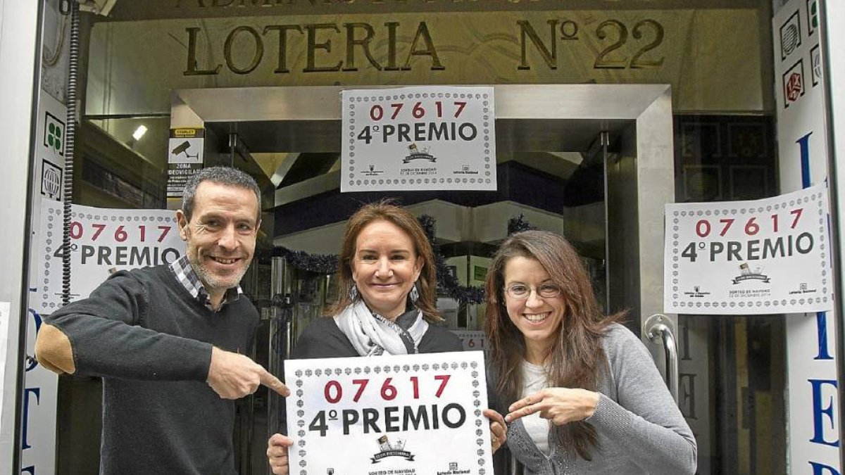 La lotera, Beatriz Álvarez, en el centro, enseña el número del cuarto premio del que sólo vendió un décimo por terminal, el único premio que cayó en Valladolid-J.M.Lostau