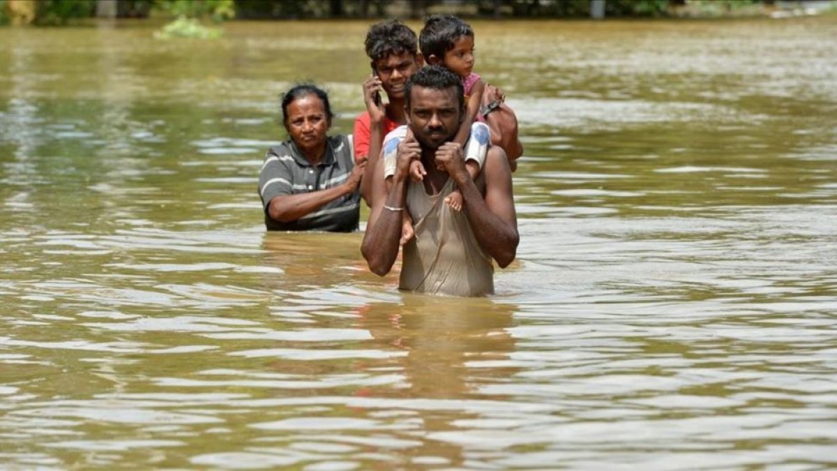 Una familia afectada por las inundaciones del ciclón Mora en la localidad de Kaduwela en Sri Lanka.-AFP