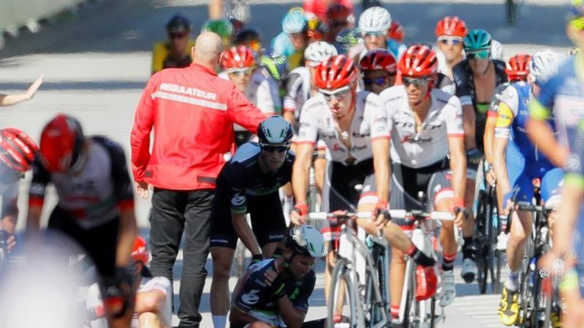 Varios miembros de la organización y compañeros atienden al ciclista británico del equipo Dimension Data Mark Cavendish (en el suelo) después de una caida múltiple durante el esprint final de la 4ª etapa del Tour de Francia-EFE