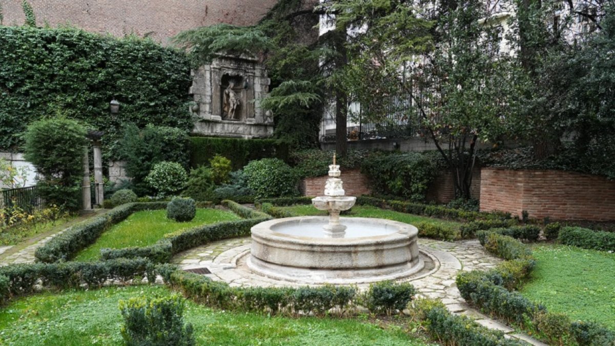 Una imagen del jardín, ayer, con la fuente y los restos de la portada del Hospital de la Resurrección.| J. M. LOSTAU