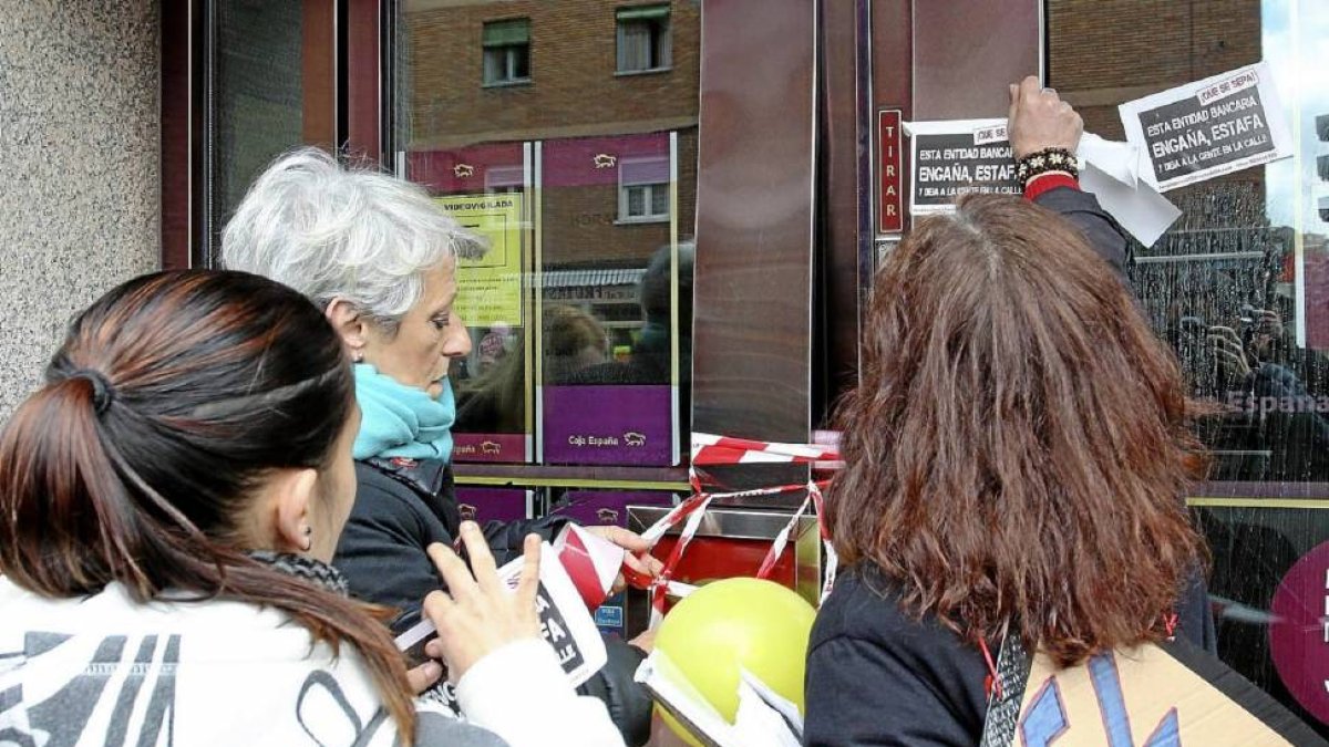 Manifestantes contra los deshaucios 'cierran' una sucursal de Caja España-Duero el pasado marzo.-Ical
