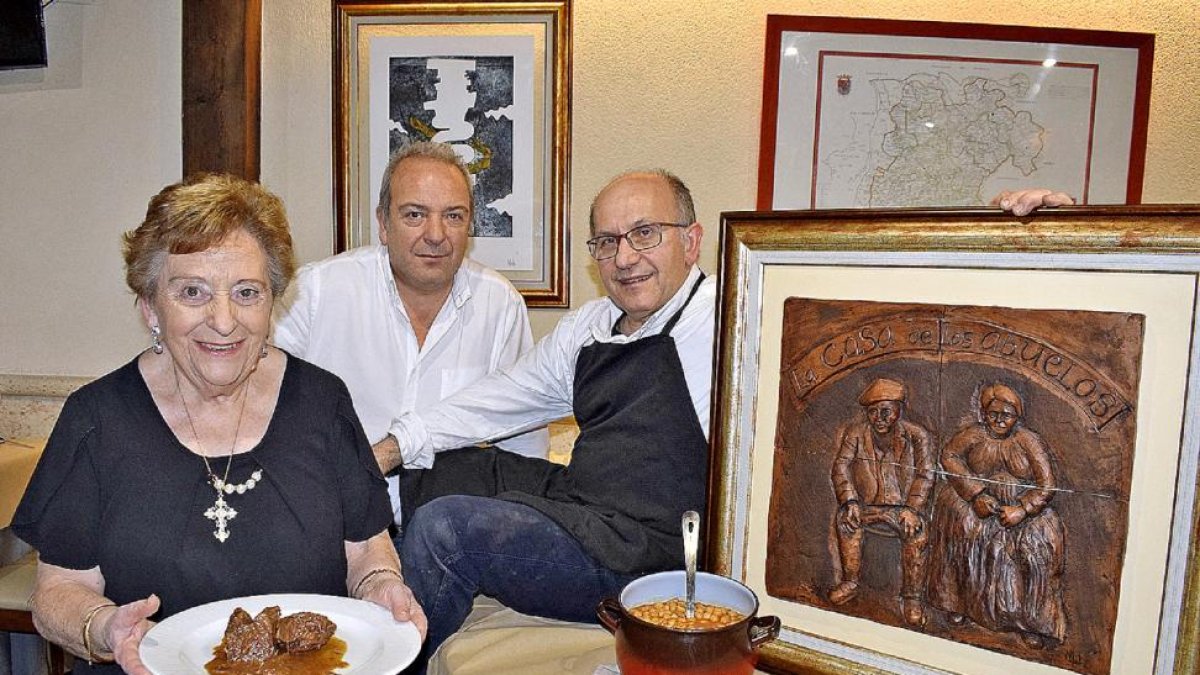 Martina Bachiller –junto a sus hijos, Susi y Carlos– con un guiso y el puchero que da nombre a las jornadas gastronómicas de febrero.-ARGICOMUNICACIÓN