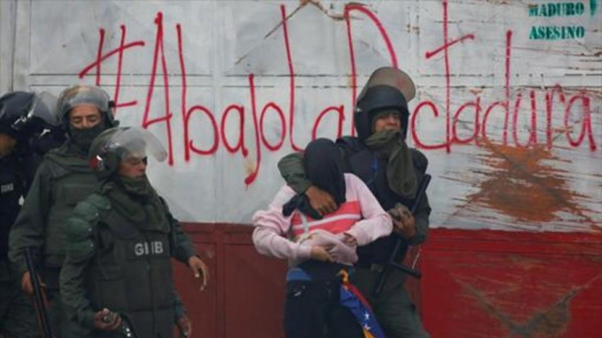 Guardias bolivarianos detienen a un manifestante durante una protesta en Caracas.-/ REUTERS / CARLOS GARCÍA RAWLINS