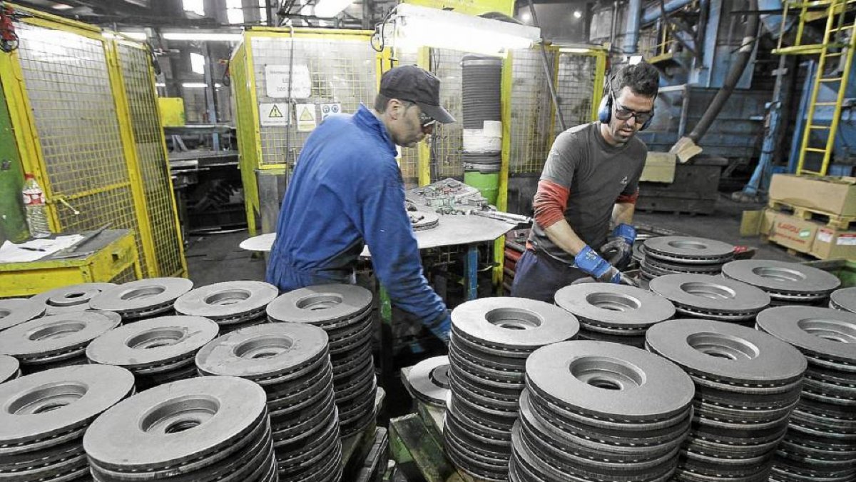 Operarios de Lingotes Especiales comprueban la calidad de los discos recién salidos de la cadena de montaje / E.M.