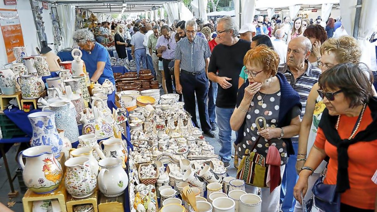 Varias personas observan las piezas de uno de los expositores de la Feria de Cerámica y Alfarería de Valladolid.-J.M. LOSTAU