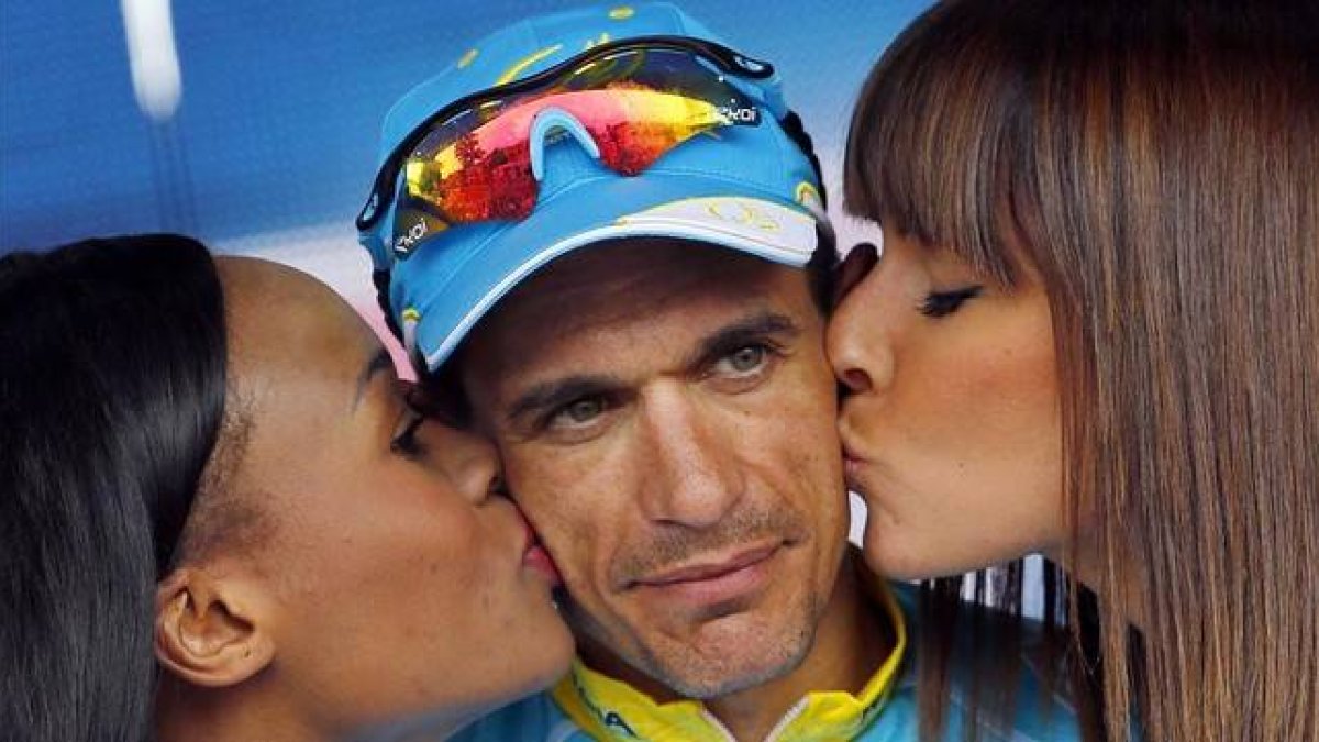 Paolo Tiralongo recibe el beso de las azafatas en podio tras ganar la novena etapa del Giro.-Foto: AFP / LUK BENIES