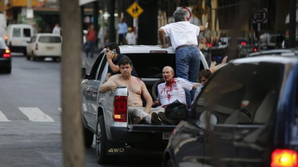 Efraín Alegre, líder del Partido Liberal (izquierda), junto a un herido en los disturbios de la madrugada del sábado en Asunción.-JORGE SAENZ