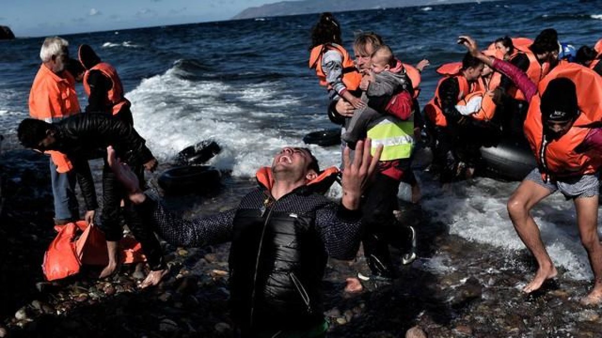 La reacción de un refugiado al llegar a la isla griega de Lesbos, este miércoles.-ARIS MESSINIS / AFP