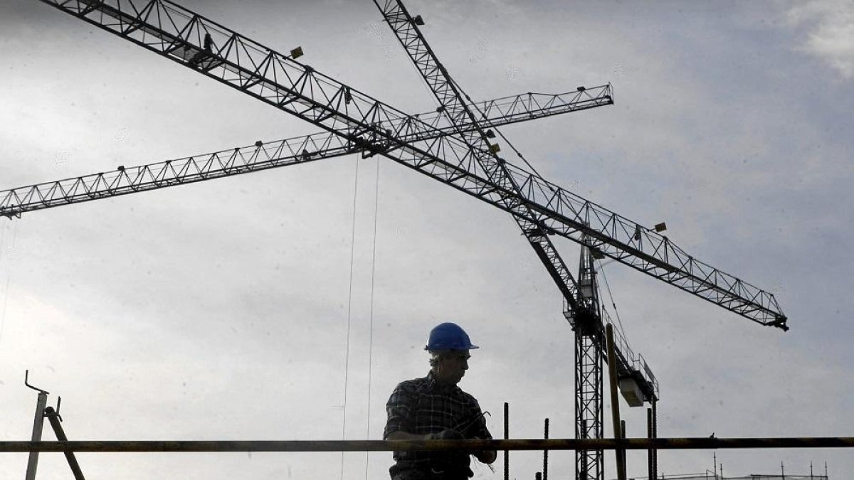 Un operario trabaja en la construcción de un bloque de pisos.