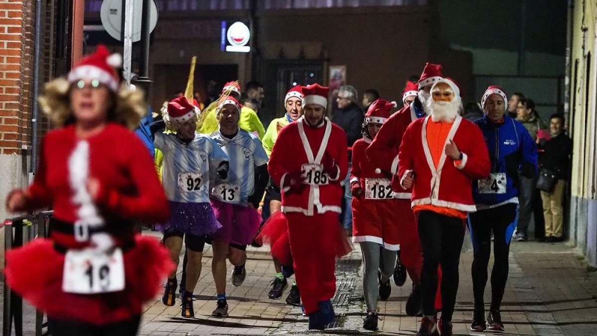 Varios corredores de la San Silvestre vianera vestidos con disfraces de Papá Noel.-PHOTOGENIC/ MIGUEL ÁNGEL SANTOS