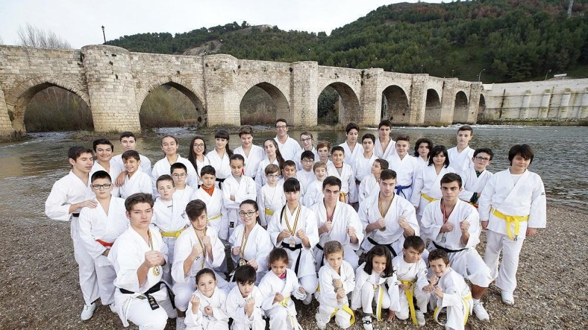 Los karatekas del ShinGiTai posan con sus karateguis frente al puente de Cabezón.-J.M. LOSTAU