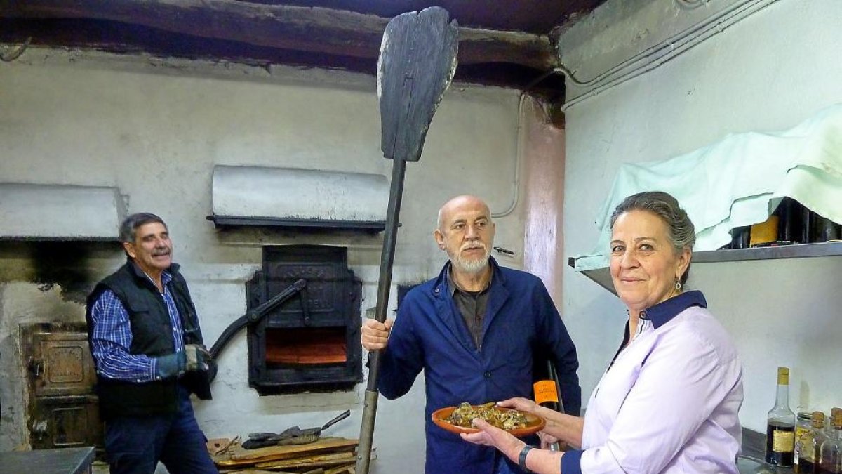 El artista Carlos León, entre Esperanza Moreno y su marido, Juan Sanz, en el horno de asar Don Juan, en Adrada de Pirón.-T. S. T.