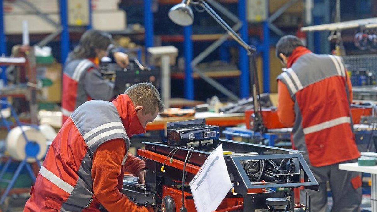 Dos trabajadores de la empresa Asti fabrican un vehículo de guiado automático.-ISRAEL L. MURILLO