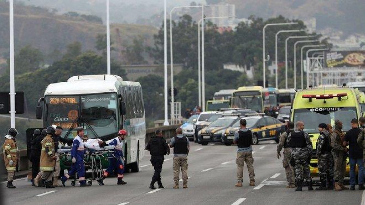 Una rehén es atendida por personal sanitario tras ser liberada por el secuestrador que la retenía en un autobús en el puente Rio-Niterói.-ANTONIO LACERDA (EFE)