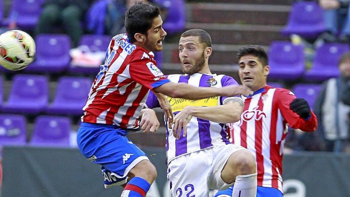 Timor intenta llevarse el balón entre los sportinguistas Nacho Cases y Carmona-J.M. LOSTAU