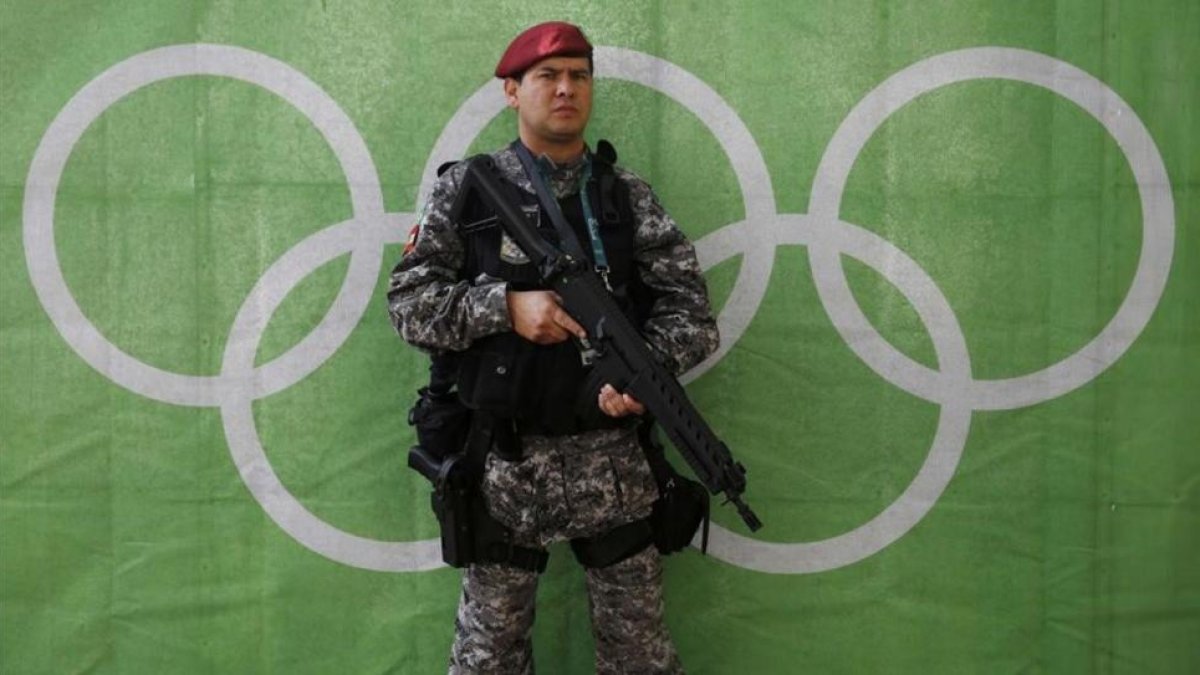 Un policía bien armado hace guardia delante de los aros olímpicos.-REUTERS / STEFAN WERMUTH