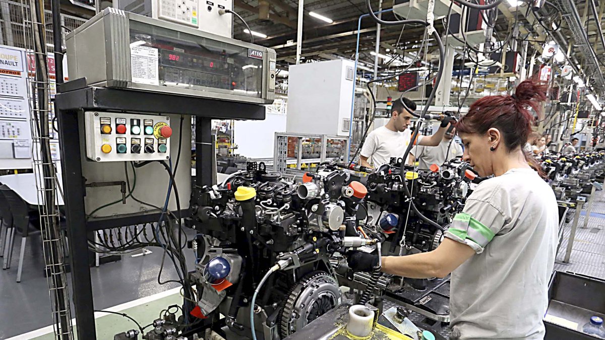 Dos operarios en sus puestos de trabajo en la factoría de motores de Renault en Valladolid.-ICAL