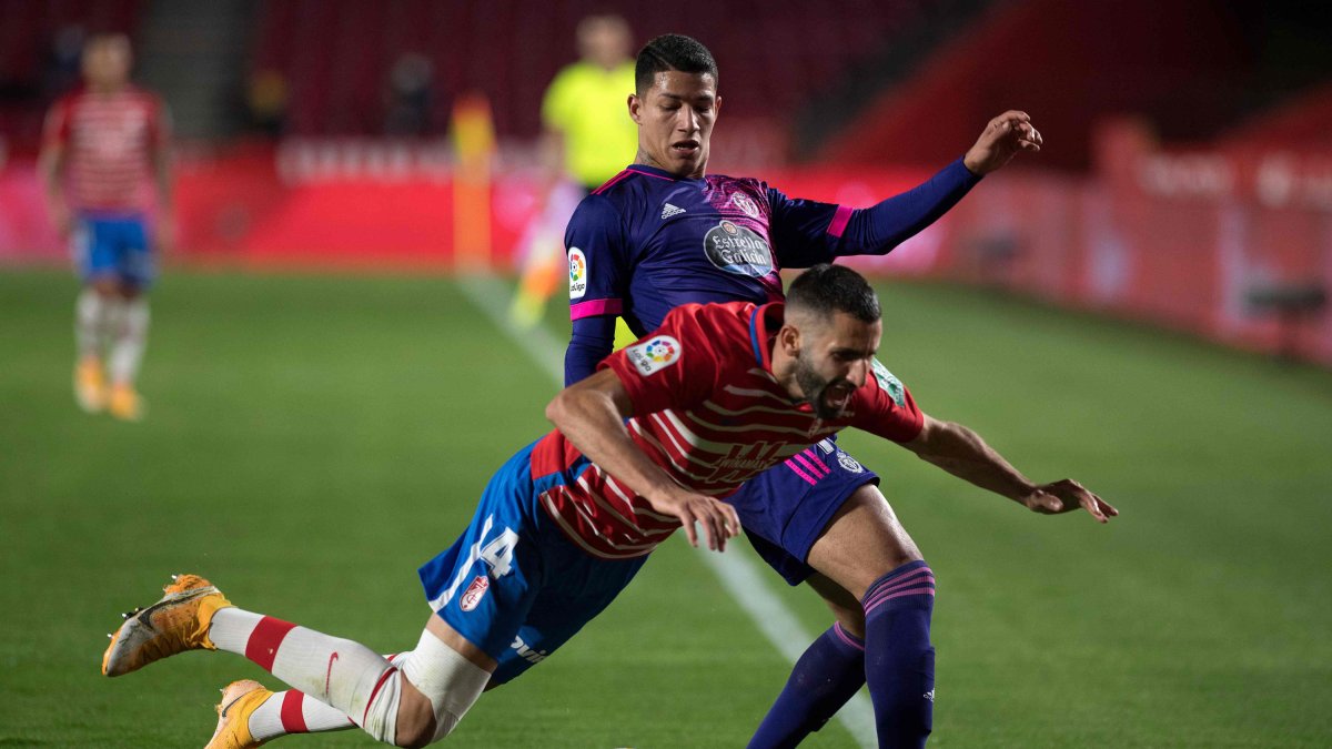 Real Valladolid's Brazilian forward Marcos Andre (back) fouls Granada's French midfielder Maxime Gonalons during the Spanish League football match between Granada FC and Real Valladolid FC at the Nuevo Los Carmenes stadium in Granada on November 22, 2020. (Photo by JORGE GUERRERO / AFP)