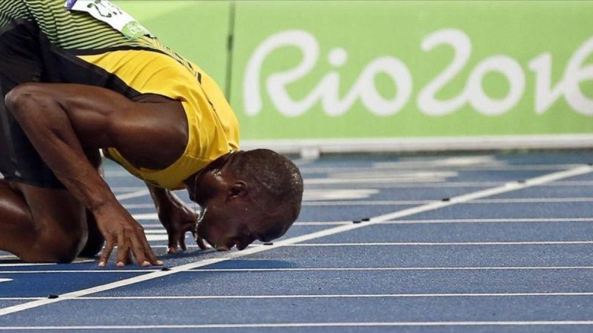 Bolt besa la pista del Estadio Olímpico tras ganar el 200.-EFE / YOAN VALAT