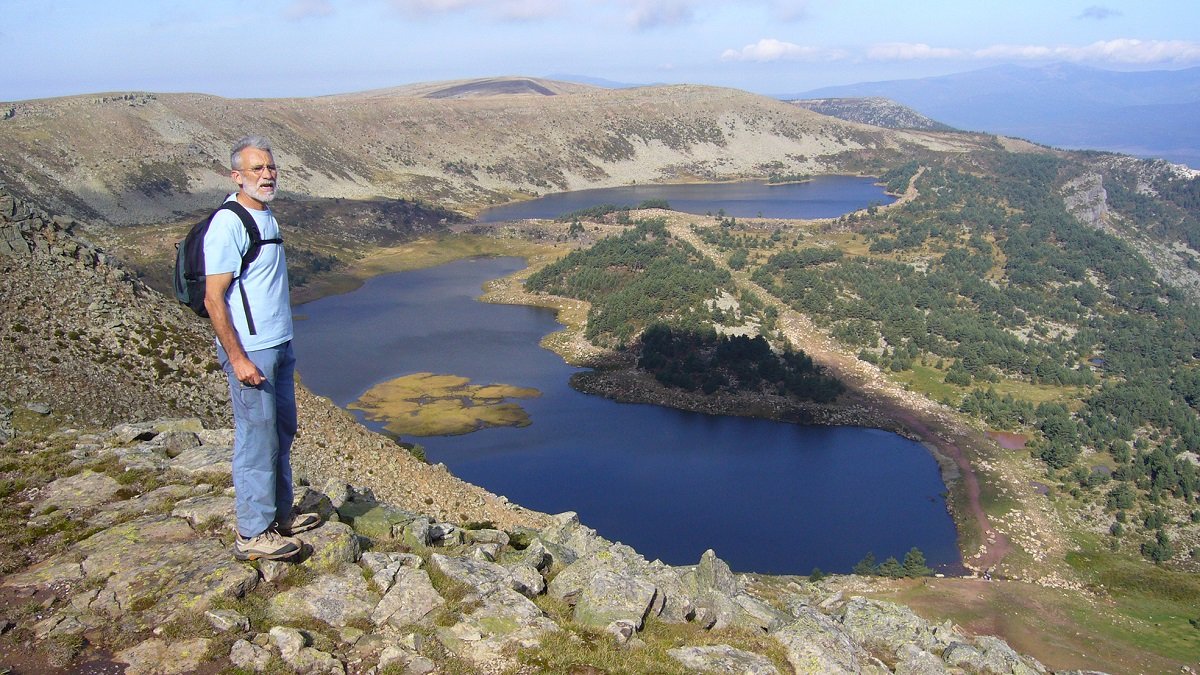 Un montañero disfruta del paisaje desde la cumbre del Pico Campiña, con las Lagunas Negra y Larga al fondo. -E.M.