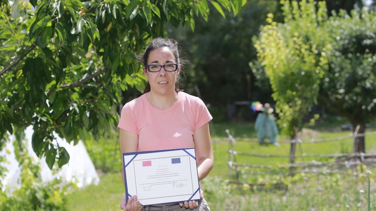 Elena Rodríguez posa junto al diploma acreditativo de su visita a China en el Huerto Los Tulipanes.-RAÚL G. OCHEA