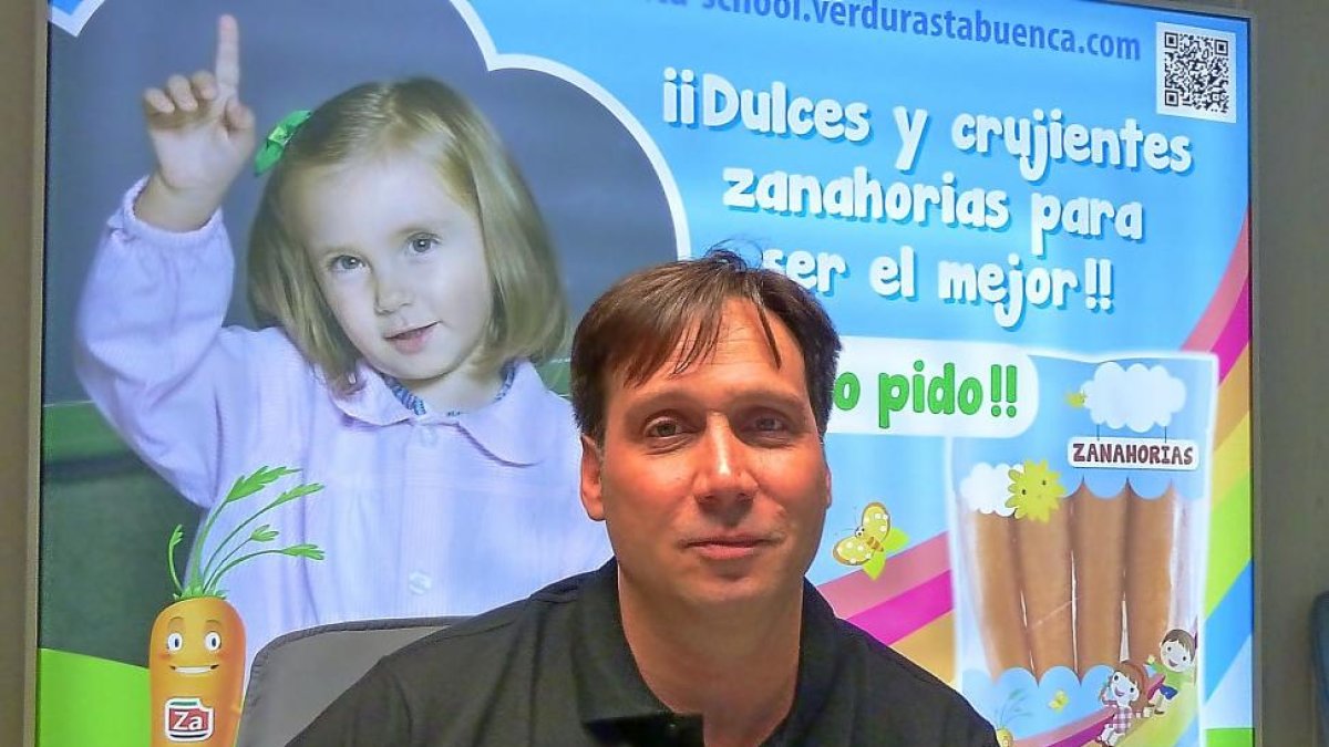 Bernardo Tabuenca delante del cartel publicitario de productos dirigidos la población infantil.-T. S. T.