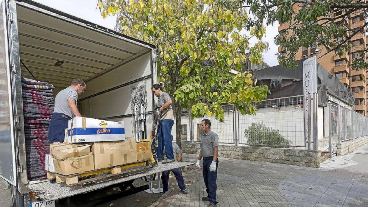 Unos operarios trasladan diversos materiales de la FCG con destino a la Fundación Casa Pintada de Mula, en Murcia.-Pablo Requejo