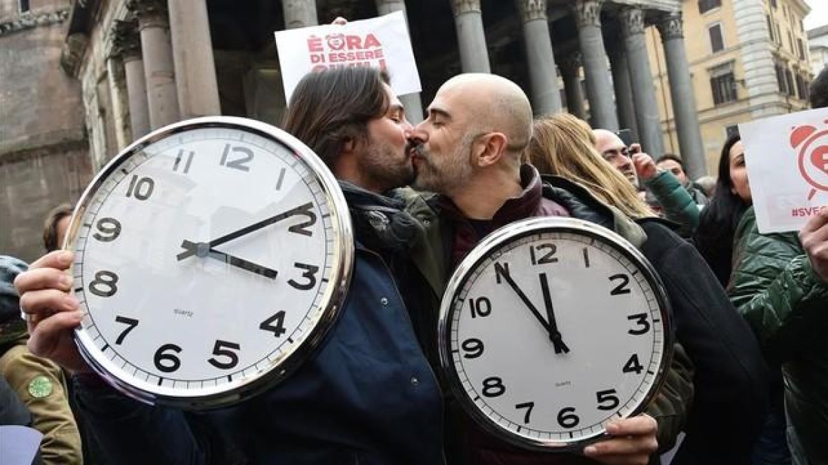 Una pareja con dos grandes relojes en la manifestación de Roma.-AFP / ALBERTO PIZZOLI