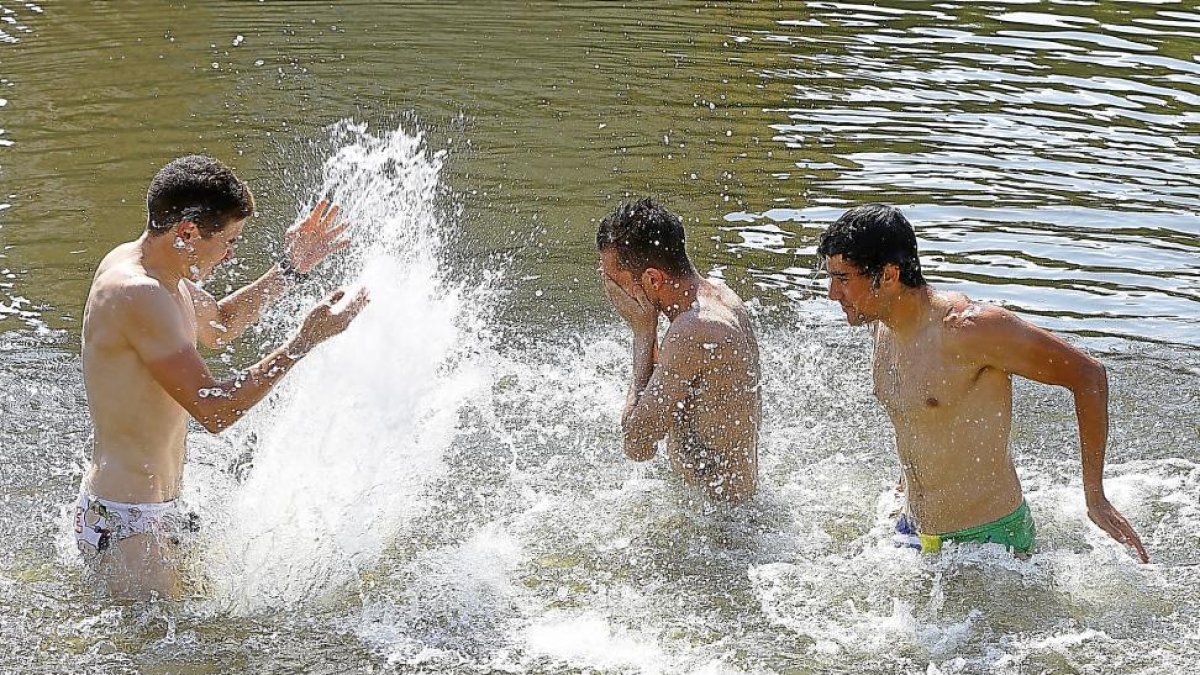 Tres jóvenes se refrescan en el río Pisuerga para contrarrestar las altas temperaturas.-J.M. Lostau