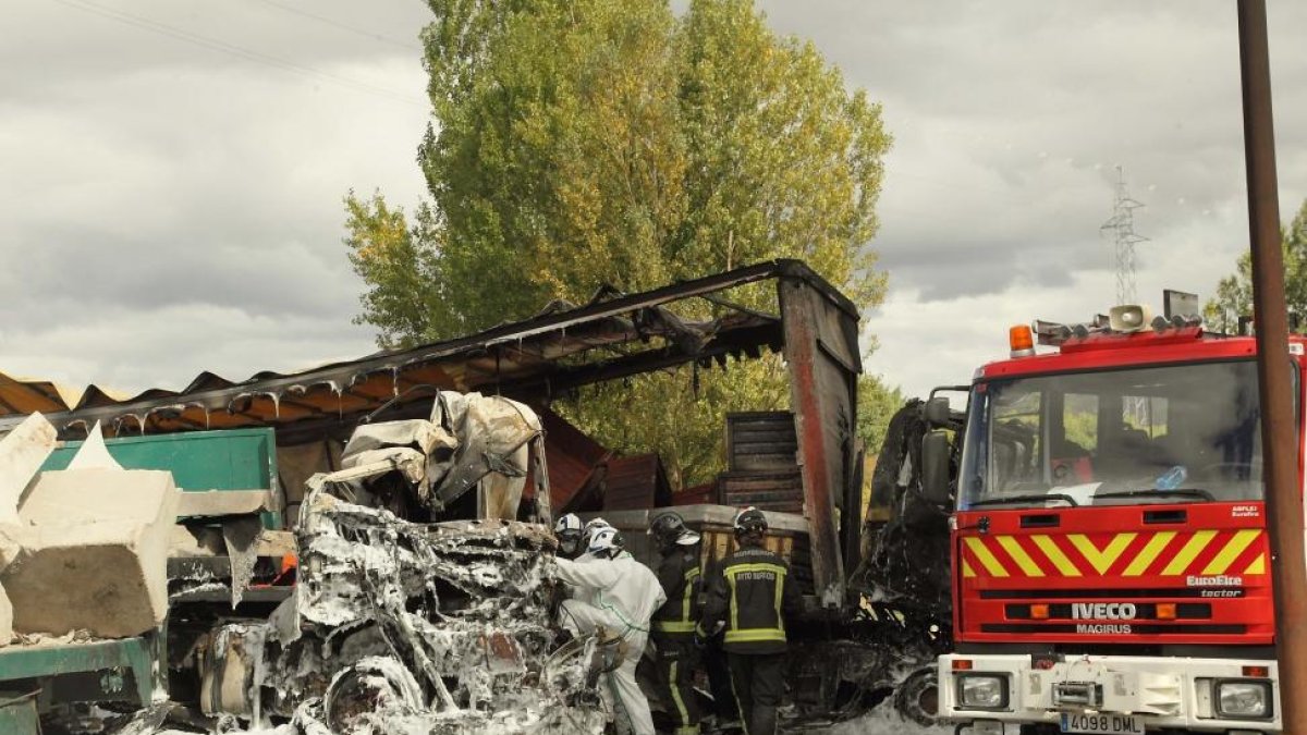 Los bomberos trabajan en el lugar en el que se produjo el choque entre los dos camiones.-G. GONZÁLEZ