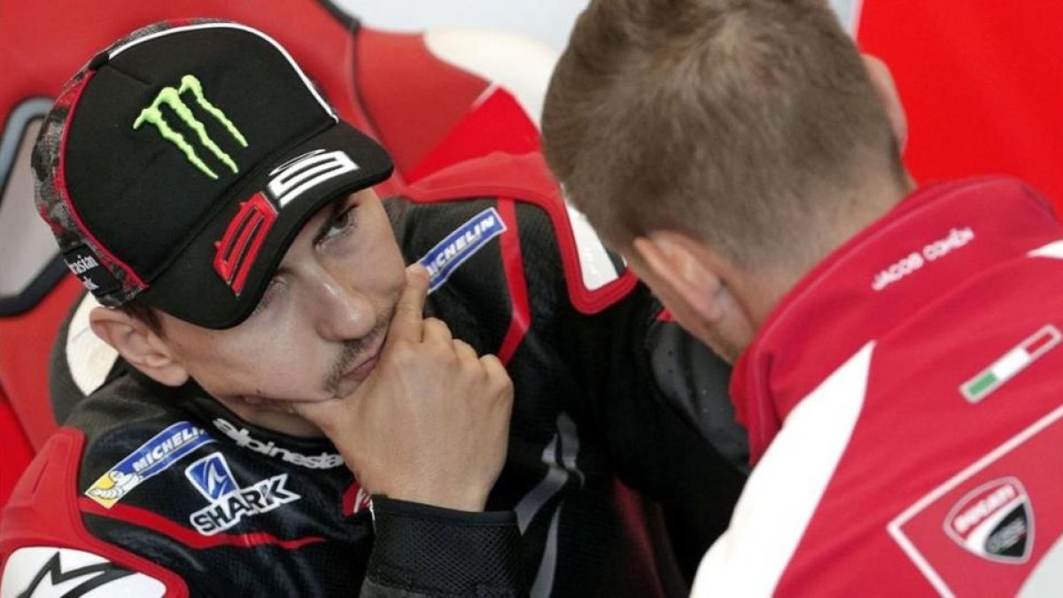 Jorge Lorenzo atiende las explicaciones del bicampeón australiano Casey Stoner, piloto probador de Ducati.-