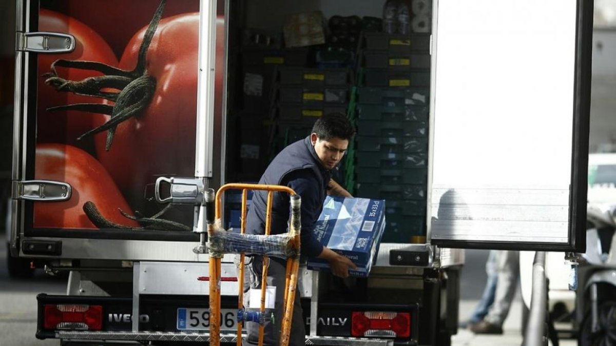 Un trabajador descarga un camión de reparto.-EUROPA PRESS