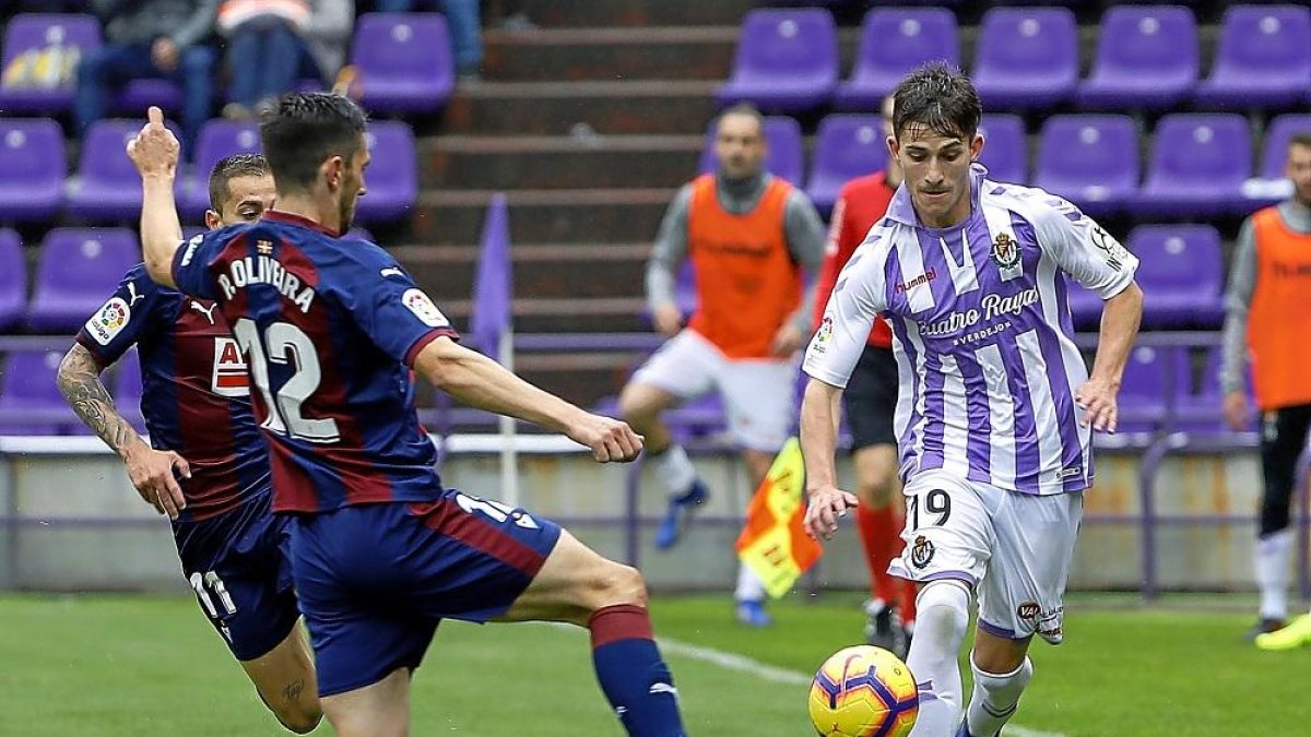 Toni elude a los eibarreses Paulo (12) y Rubén Peña.-J.M. LOSTAU