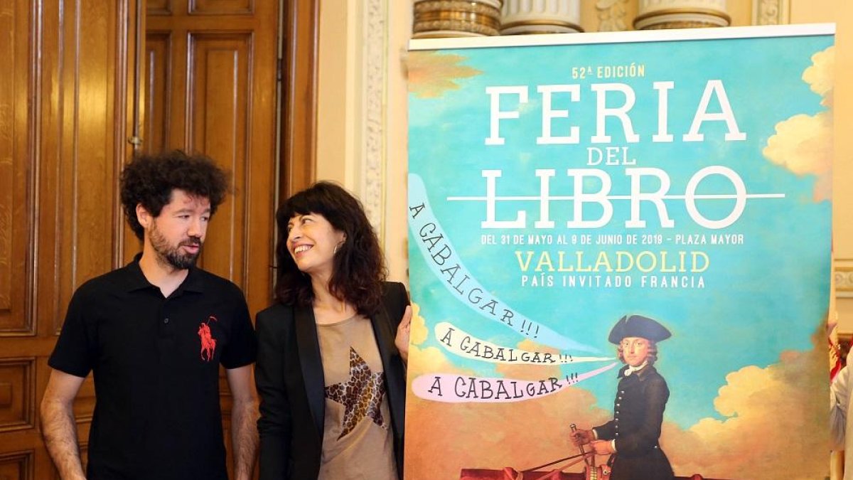 Julio Falagán y Ana Redondo junto al cartel que anuncia la Feria del Libro.-ICAL
