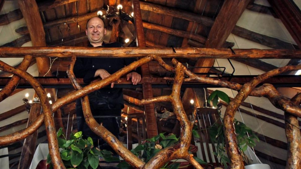 Manuel Zapater asoma por el hueco por el que entraba la paja, hoy ventanal del comedor en la planta superior.-MARIO TEJEDOR