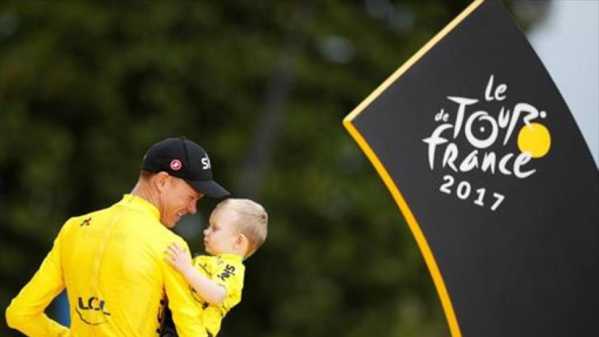Chris Froome, el ciclista británico, sostiene en brazos a Kellan, su hijo, en el podio de París.-REUTERS / CHRISTIAN HARTMANN