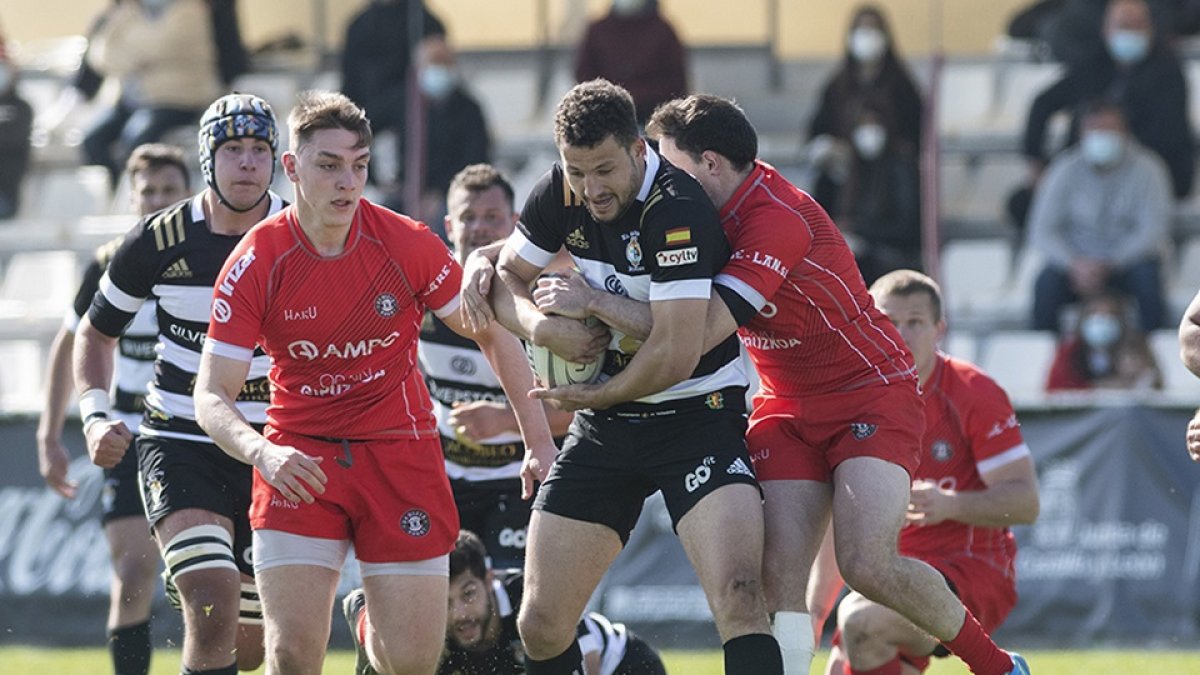 Miguel Lainz es placado por un jugador rival en un encuentro disputado entre SilverStorm El Salvador y AMPO Ordizia la pasada temporada en los campos de Pepe Rojo. / J. L. USEROS