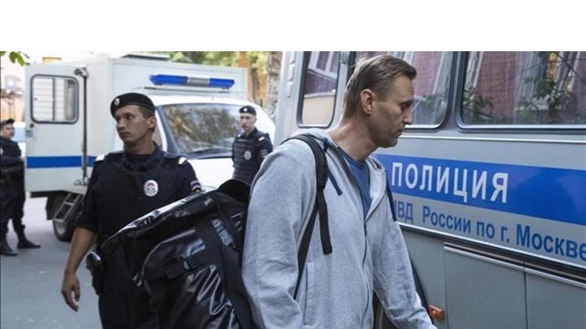 Navalny abandona el tribunal donde fue condenado hacia la prisión rodeado de agentes policiales. /-PAVEL GOLOVKIN / AP