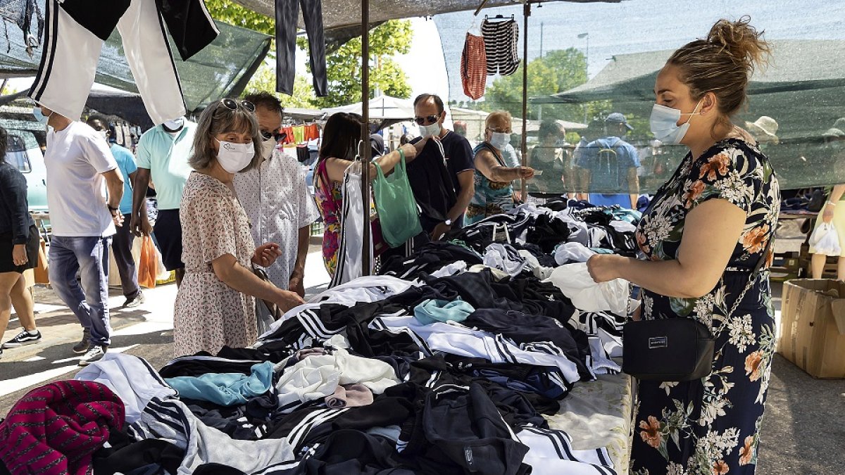 Una comerciante vende ropa en su puesto del mercadillo del real de la feria.- REPORTAJE GRÁFICO DE PHOTOGENIC/PABLO REQUEJO