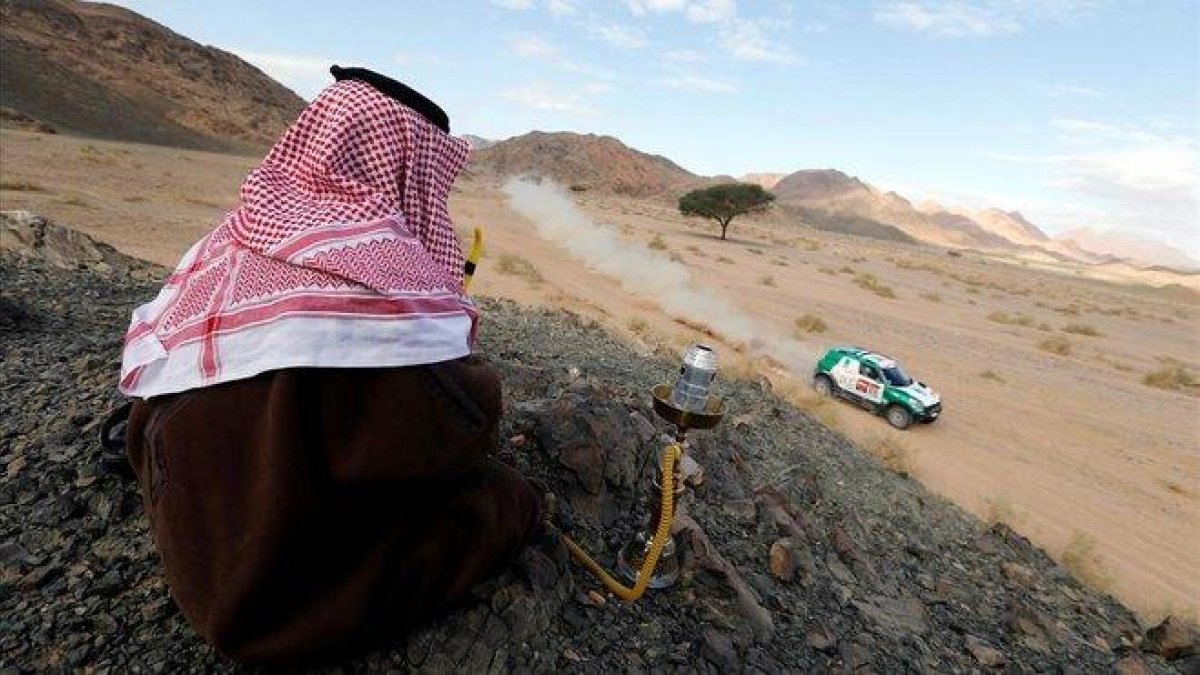 Un espectador observa el paso del Dakar por el desierto de Arabia.-