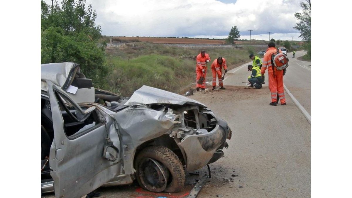 El vehículo accidentado y al fondo las labores de medición.-MARIO TEJEDOR
