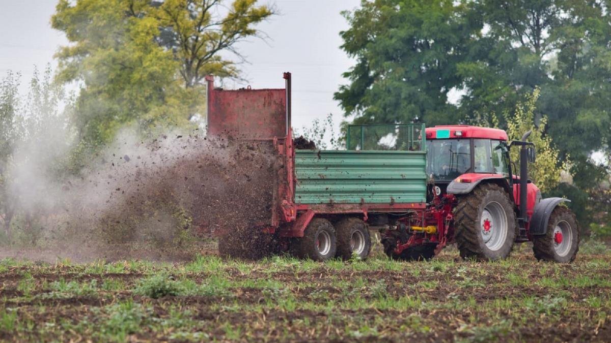 Un agricultor realiza trabajos agrícolas con maquinaria sobre un campo recién abonado.-ECB
